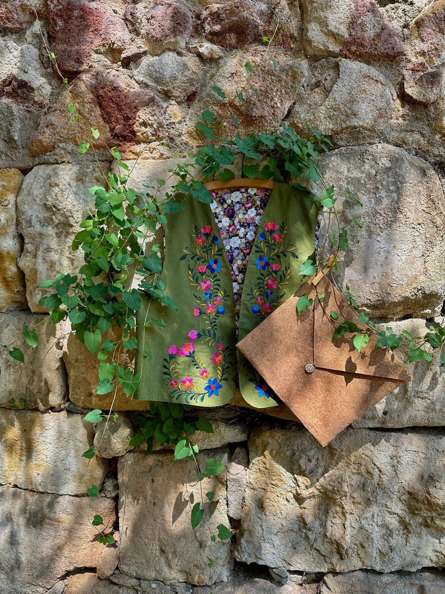 Decorative mailbox with floral design attached to a stone wall