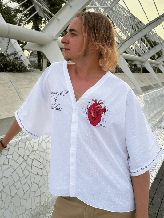 Person wearing a white shirt with a red heart design outdoors