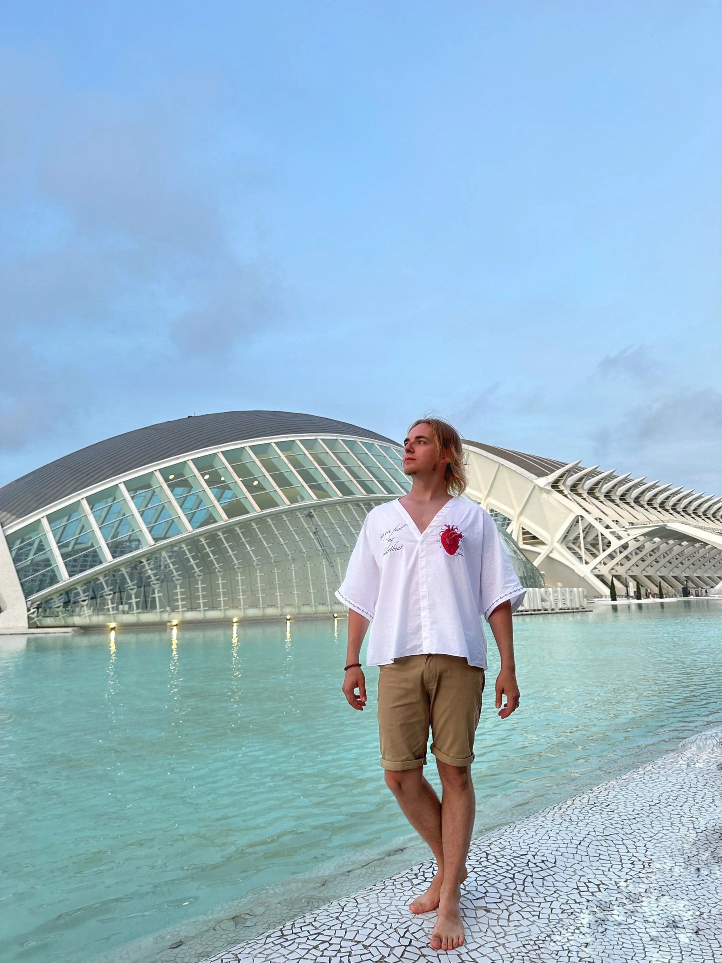 Person standing by a modern architectural structure with a clear sky