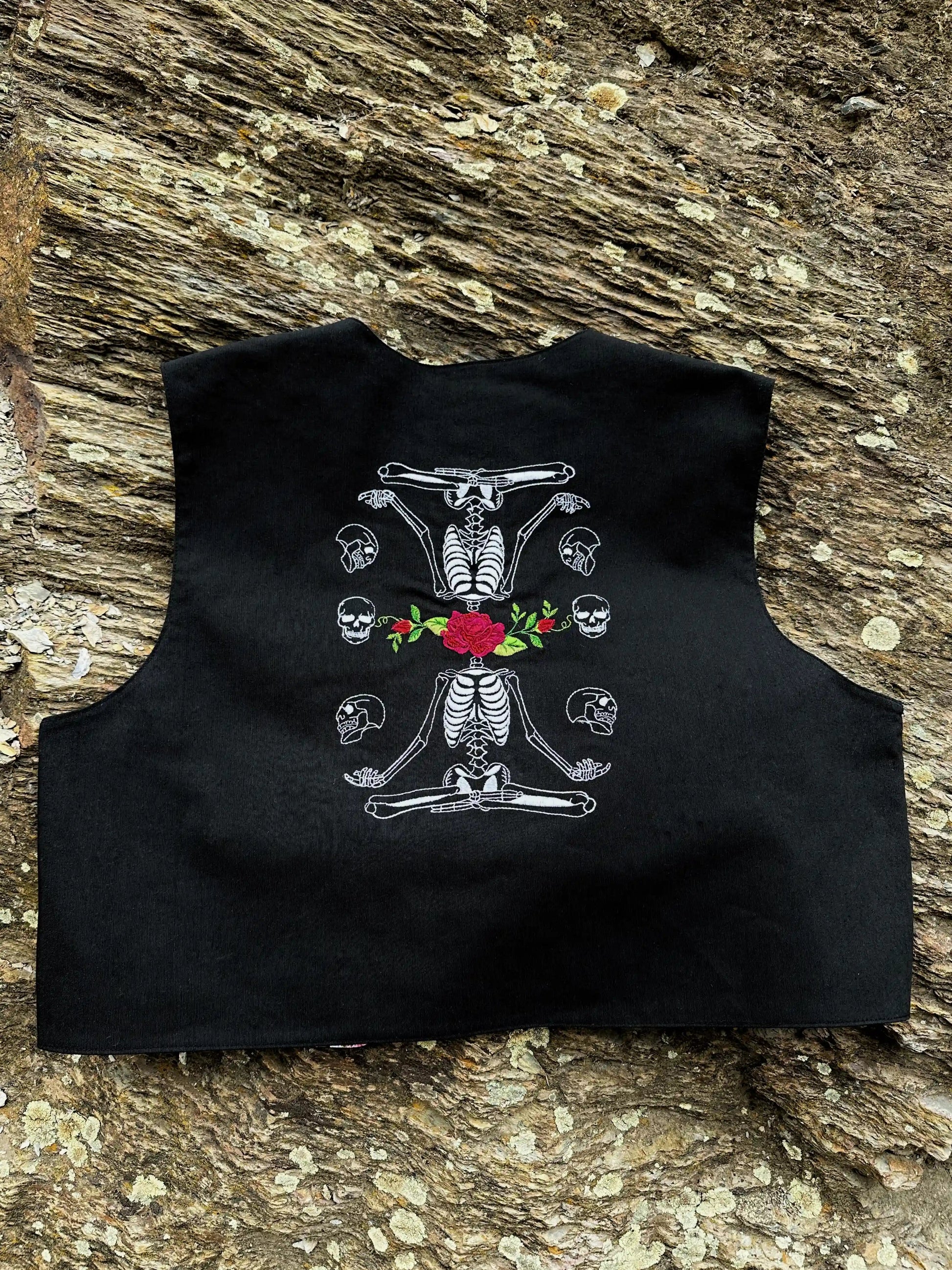 Black sleeveless top with skeleton and floral design on a textured surface