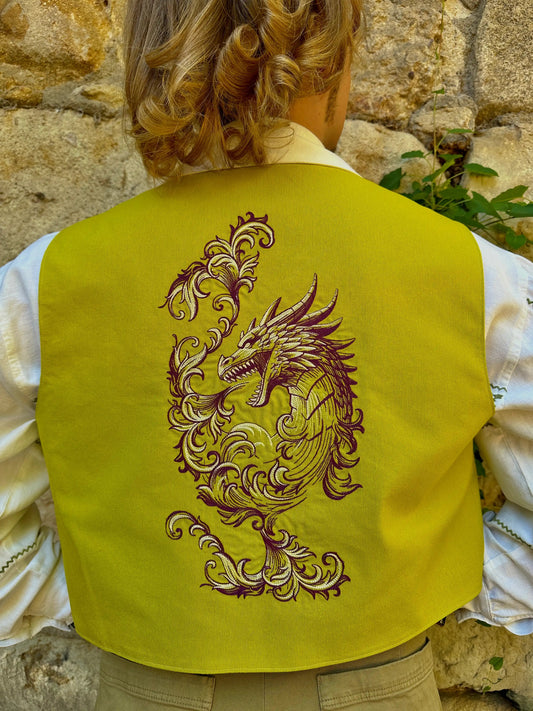 Person wearing a yellow vest with a dragon design against a stone wall background