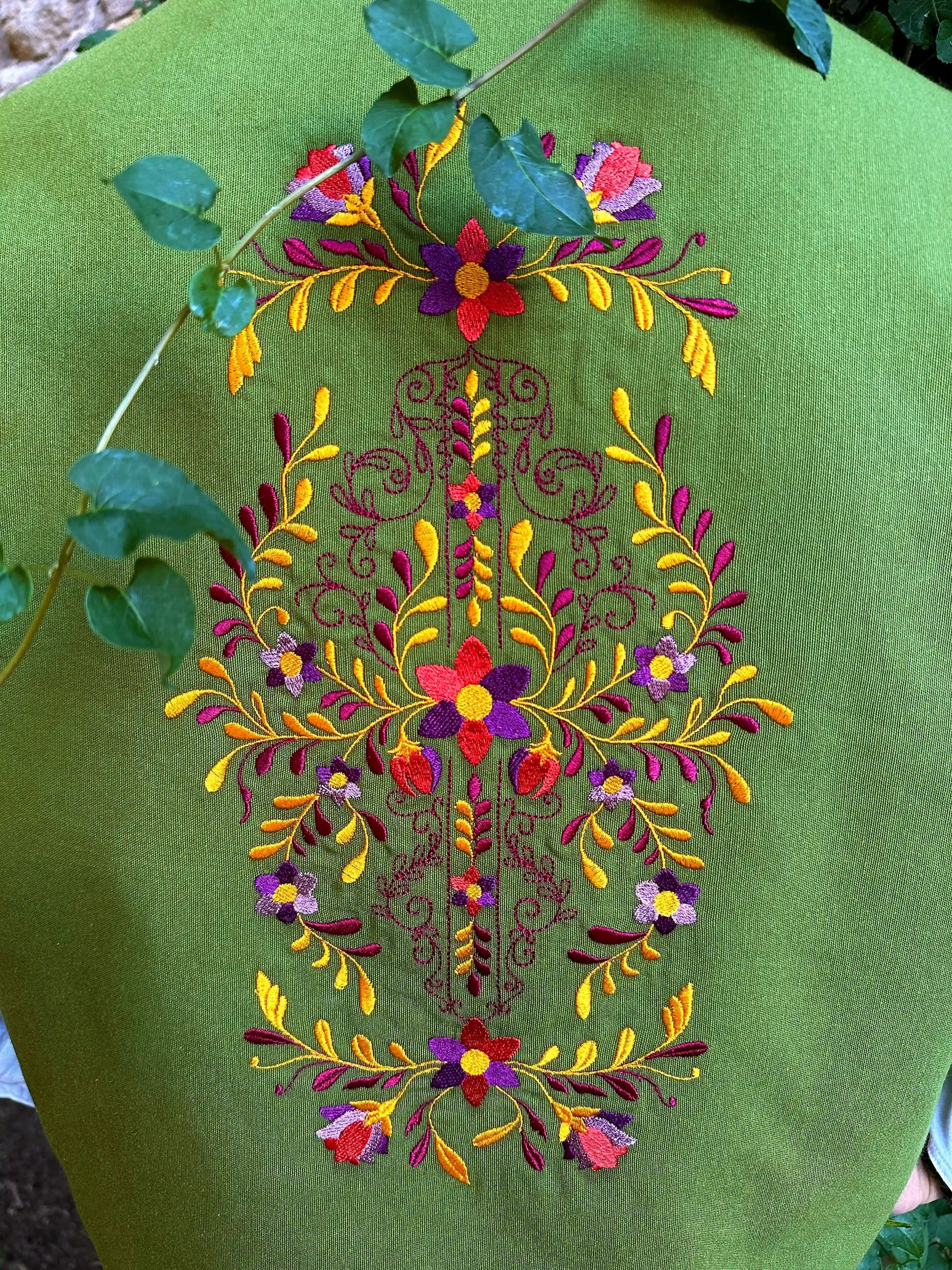 Green fabric with colorful floral embroidery