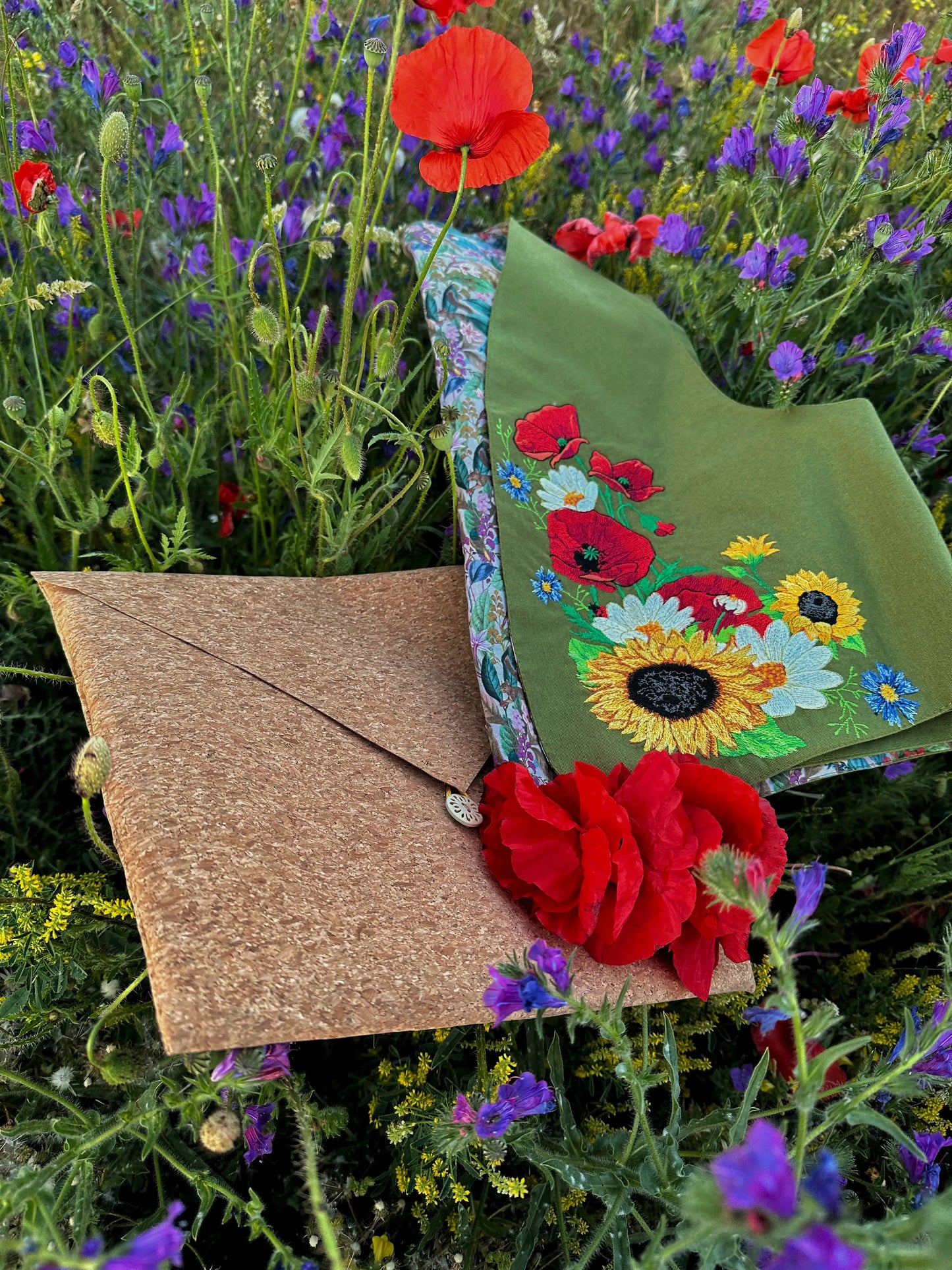 Floral embroidered clutch with red flowers against a natural background
