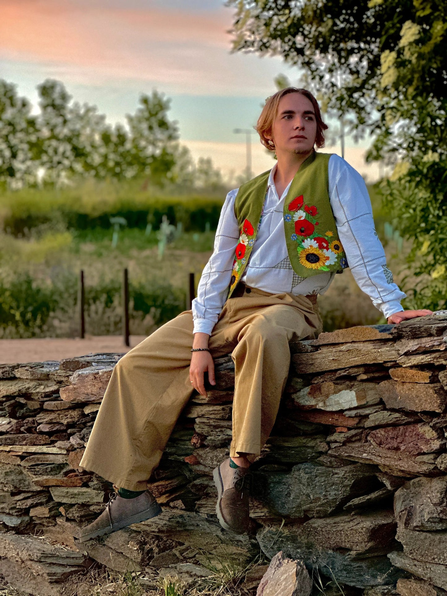 Person sitting on a stone wall with a scenic background