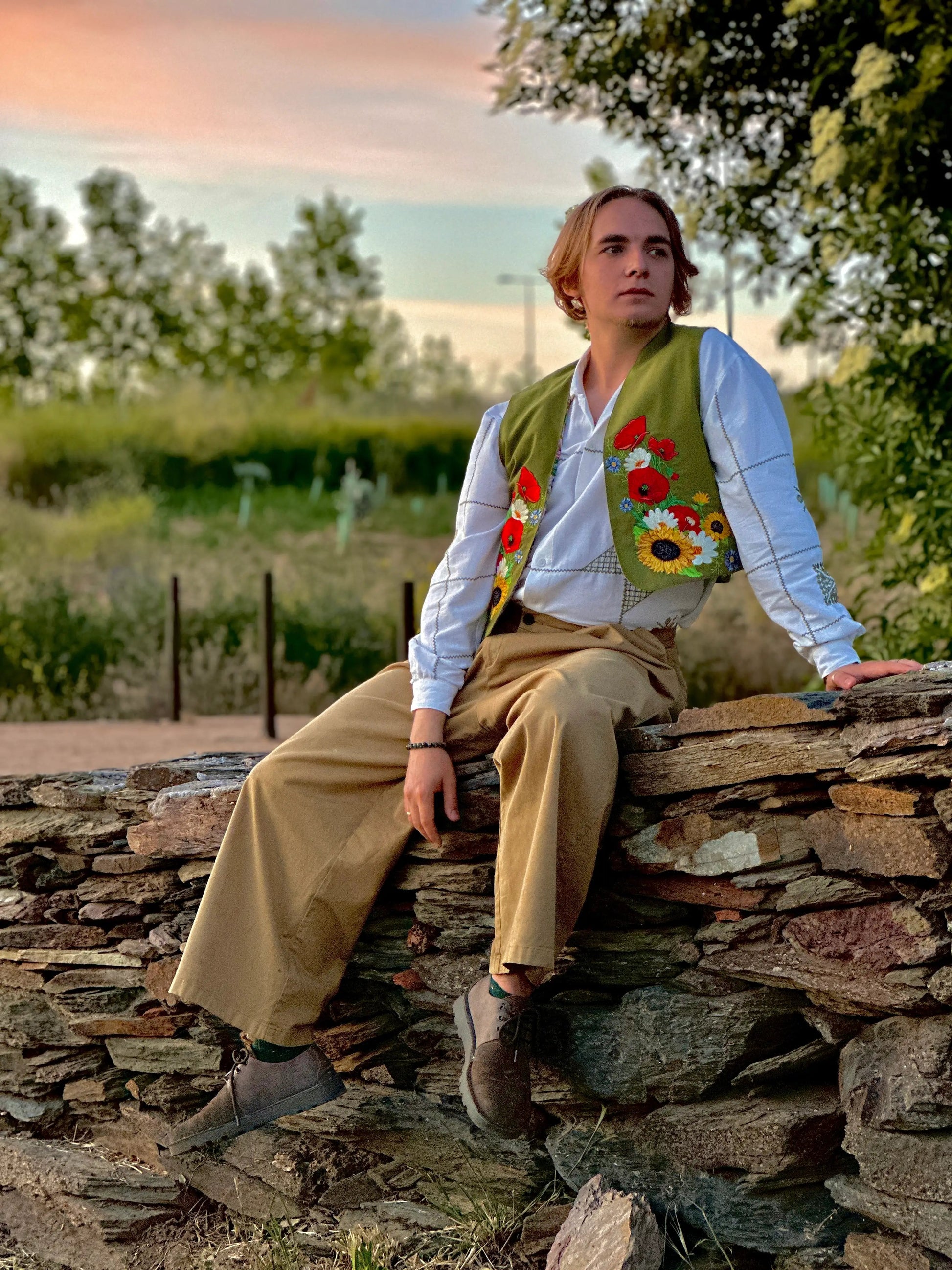 Person sitting on a stone wall with a scenic background