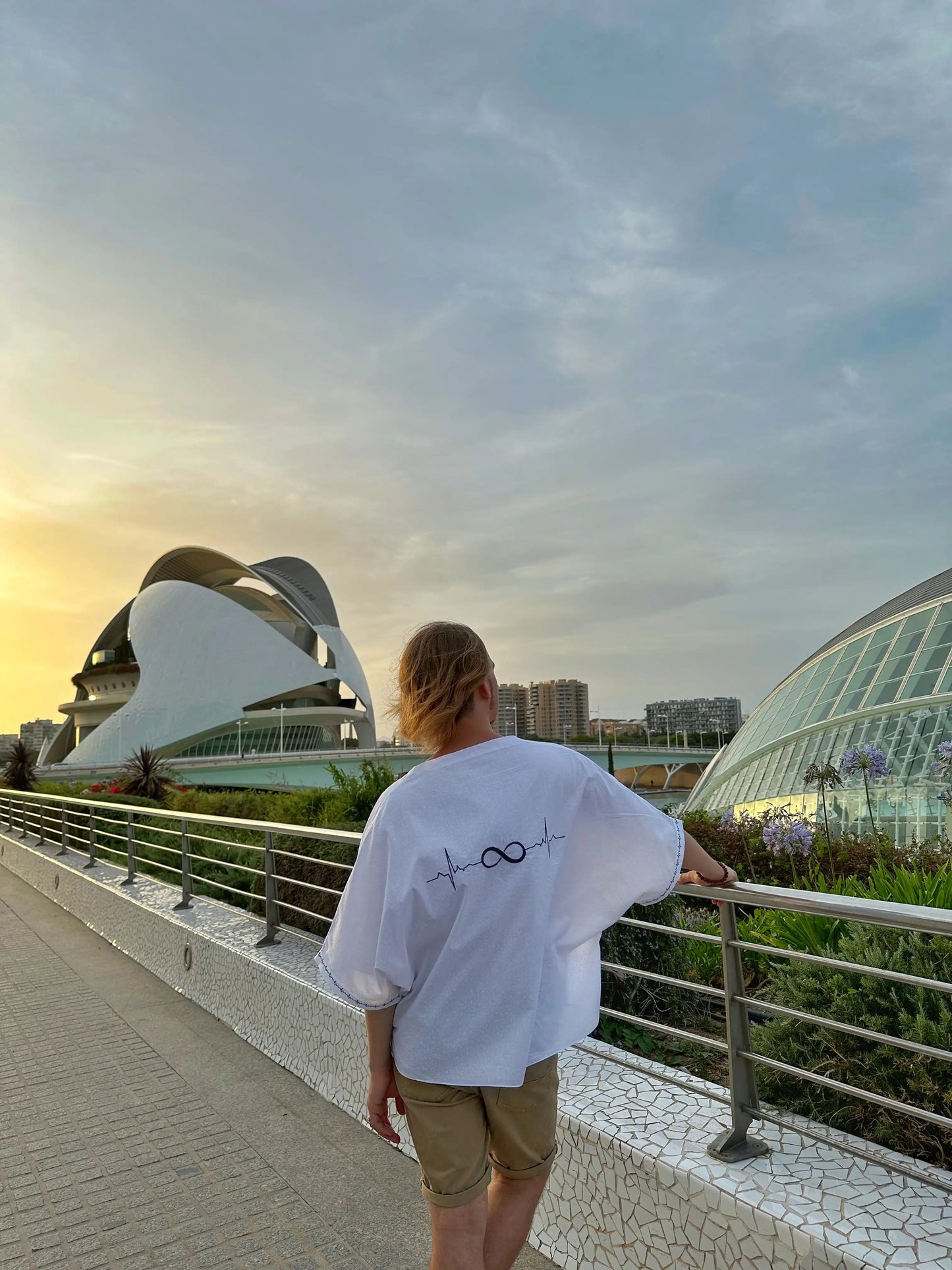 Person standing on a pathway with futuristic architecture in the background