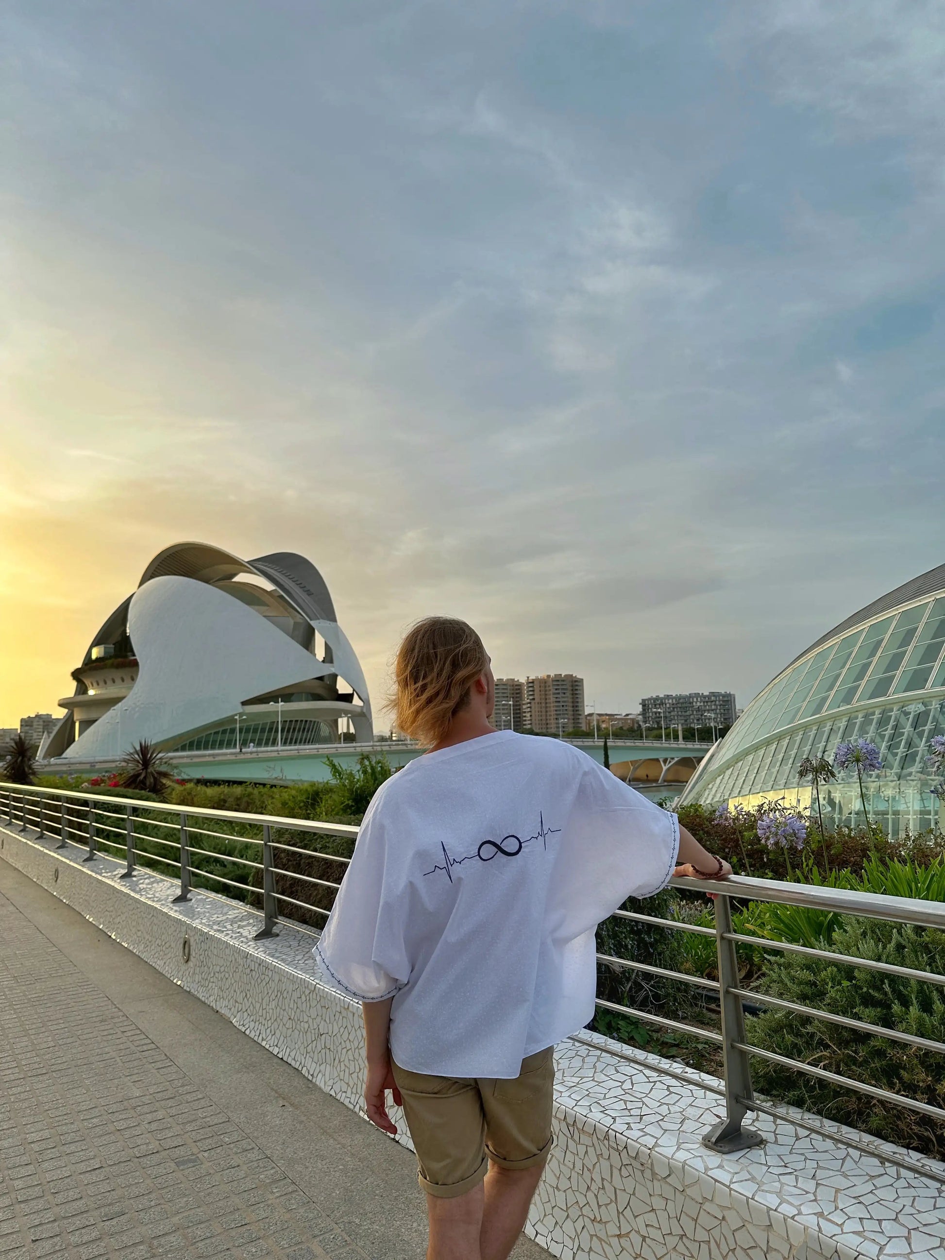 Person standing on a pathway with futuristic architecture in the background