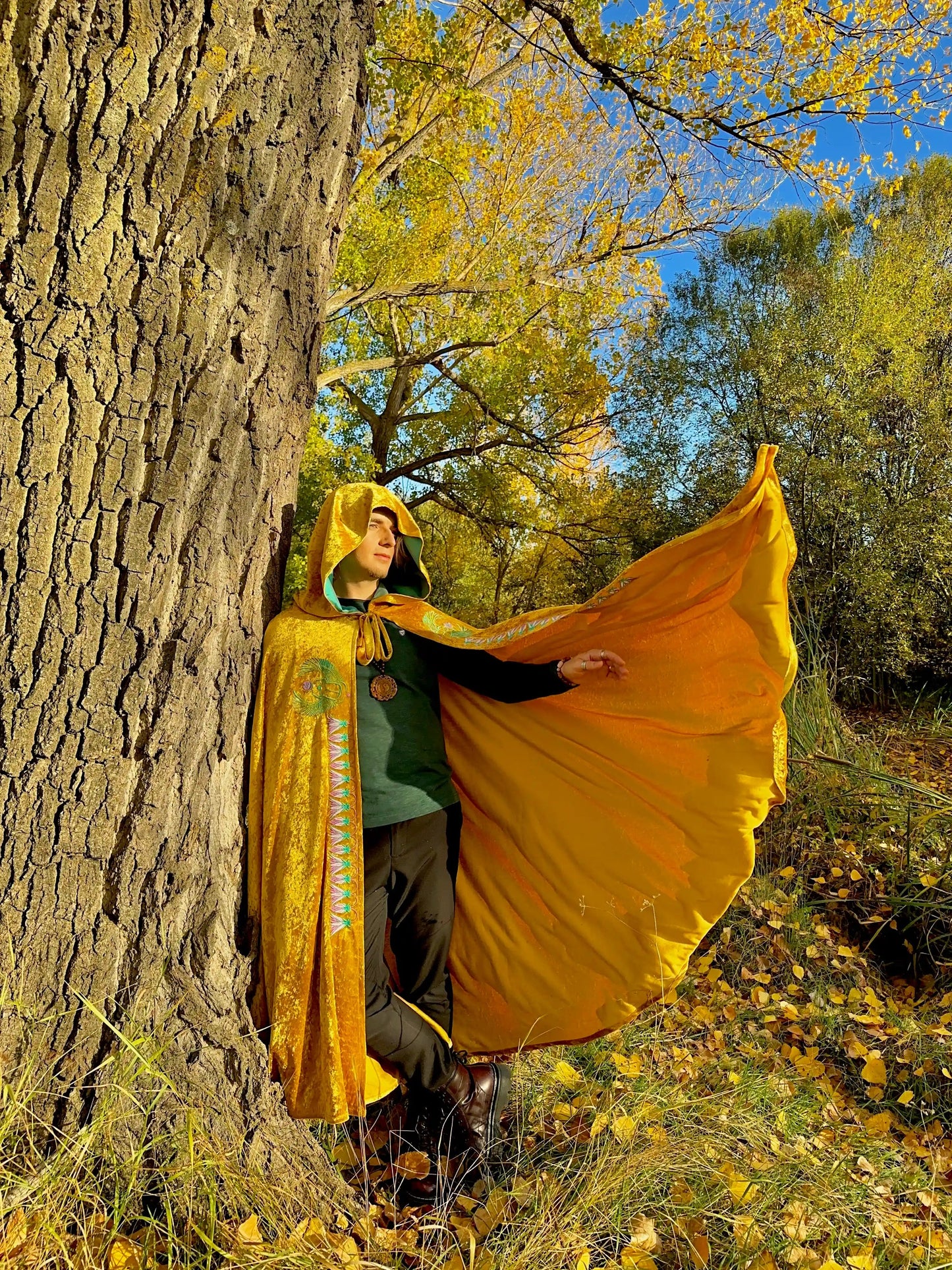 Person wearing a yellow cloak in an autumn forest