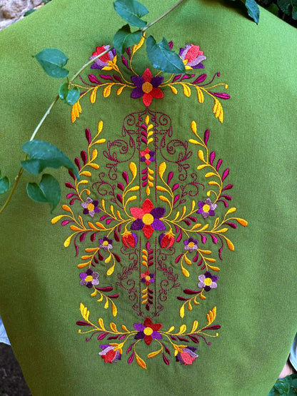 Green fabric with colorful floral embroidery