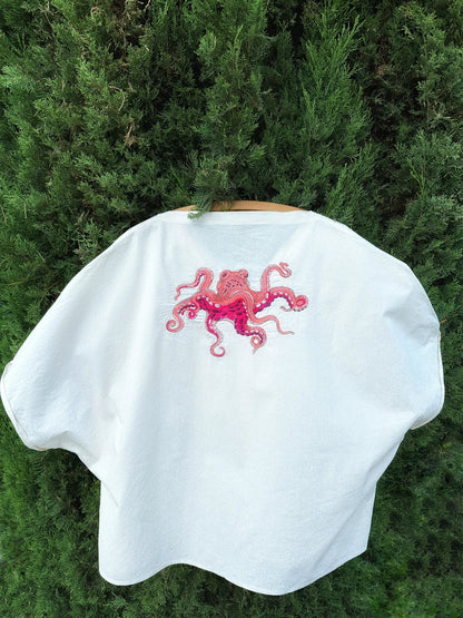 White cape with pink octopus design on a green background